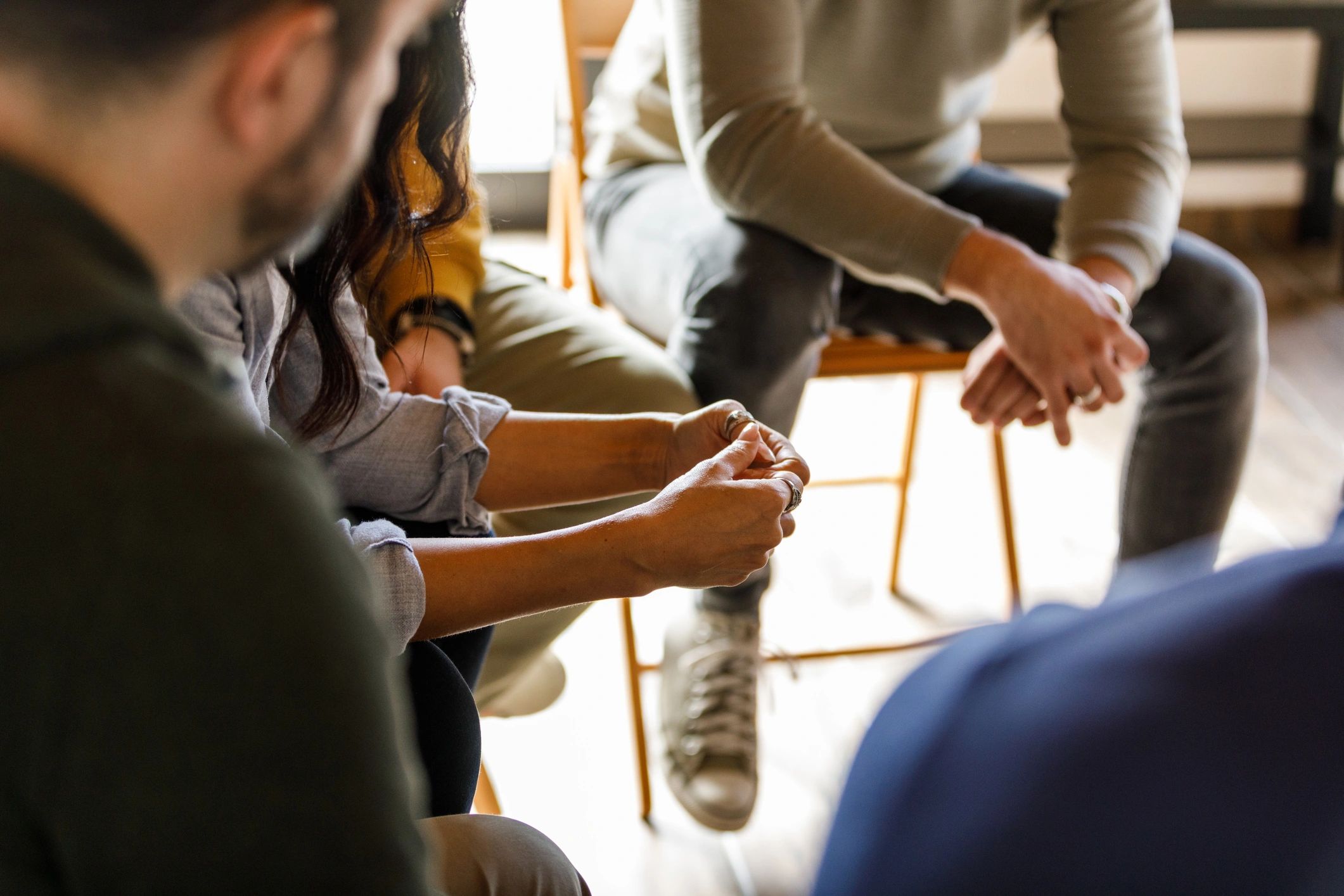 Hands of people in a group setting, symbolizing peer support